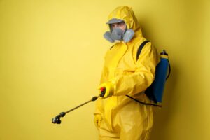 exterminator in yellow with chemical spray